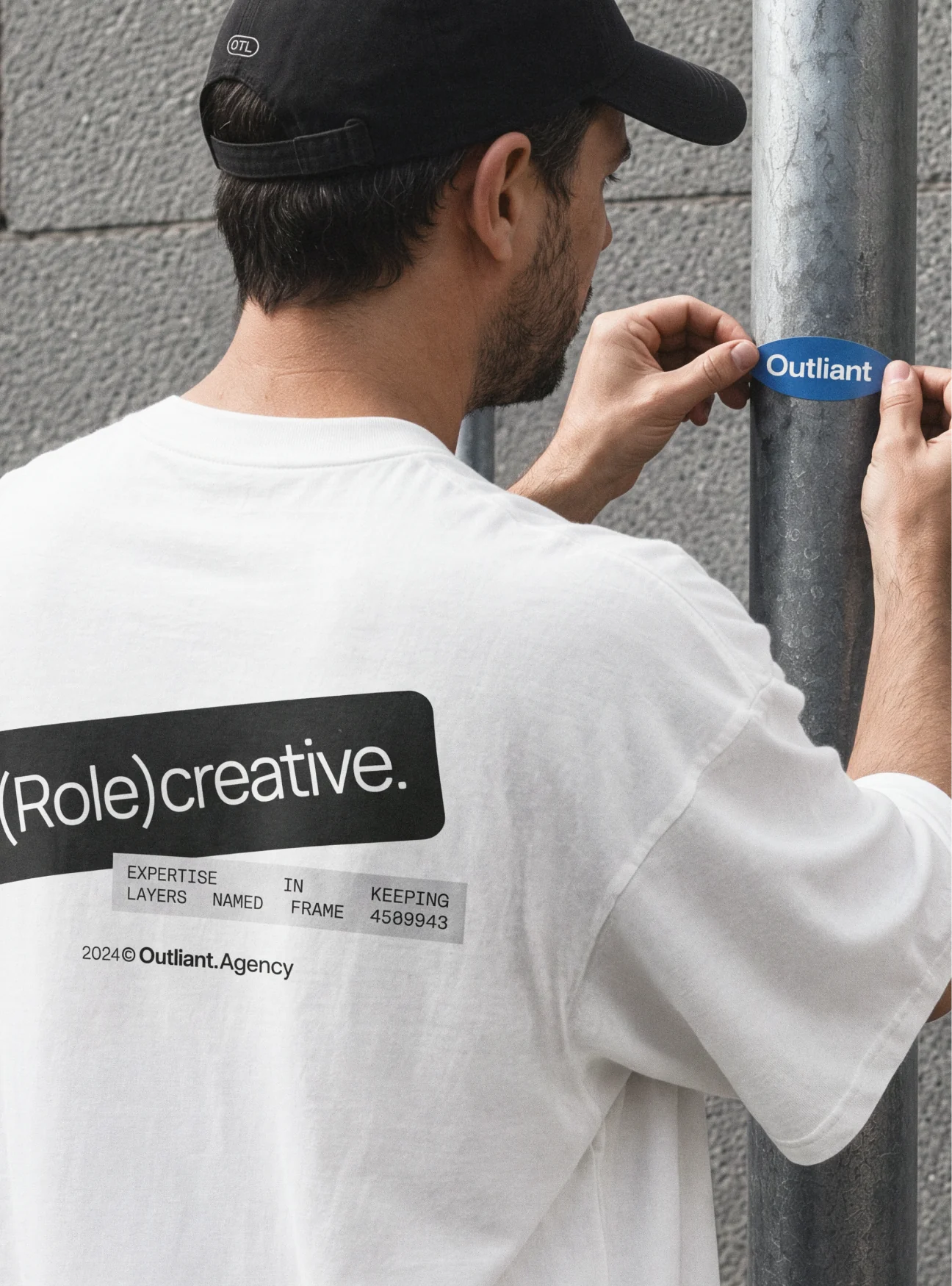 A person applying an Outliant Role Creative sticker.
