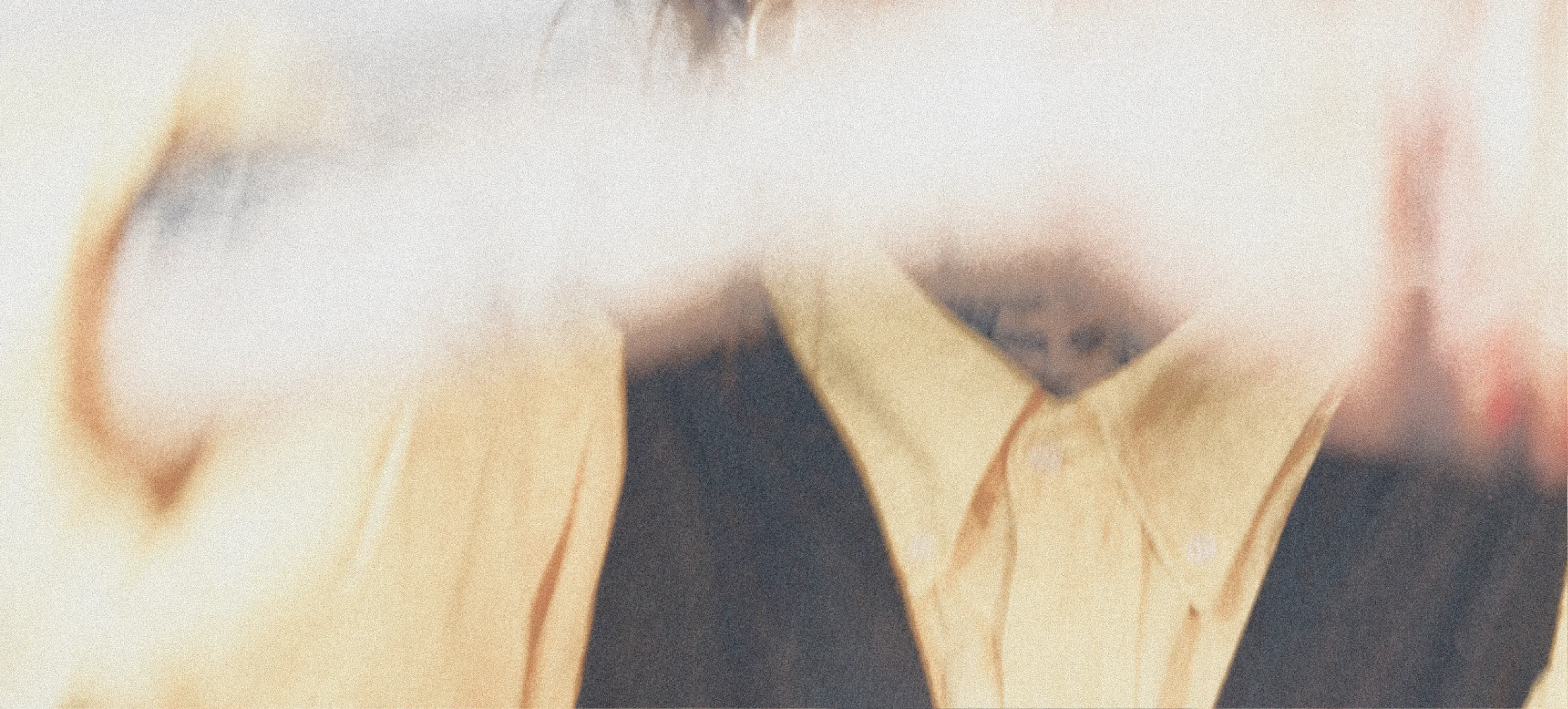 A close-up of pale yellow shoes against a dark outfit.